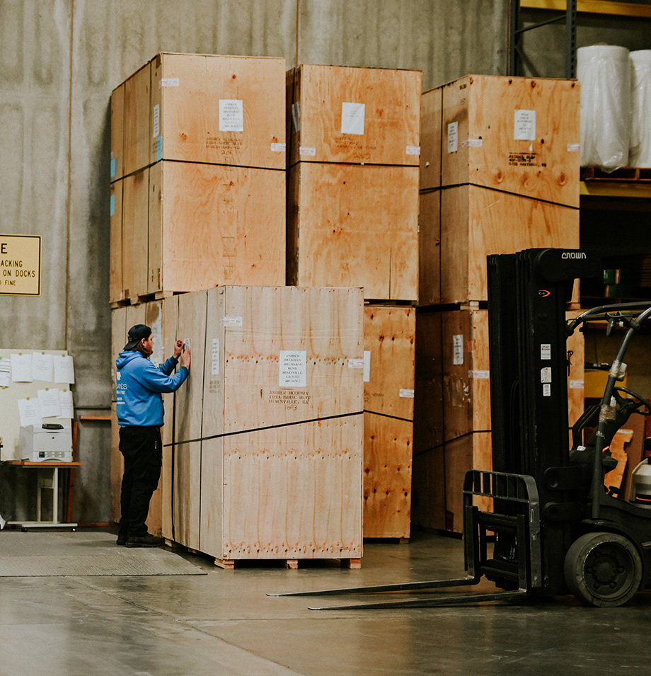 Planes employee writing on form on a large packing crate